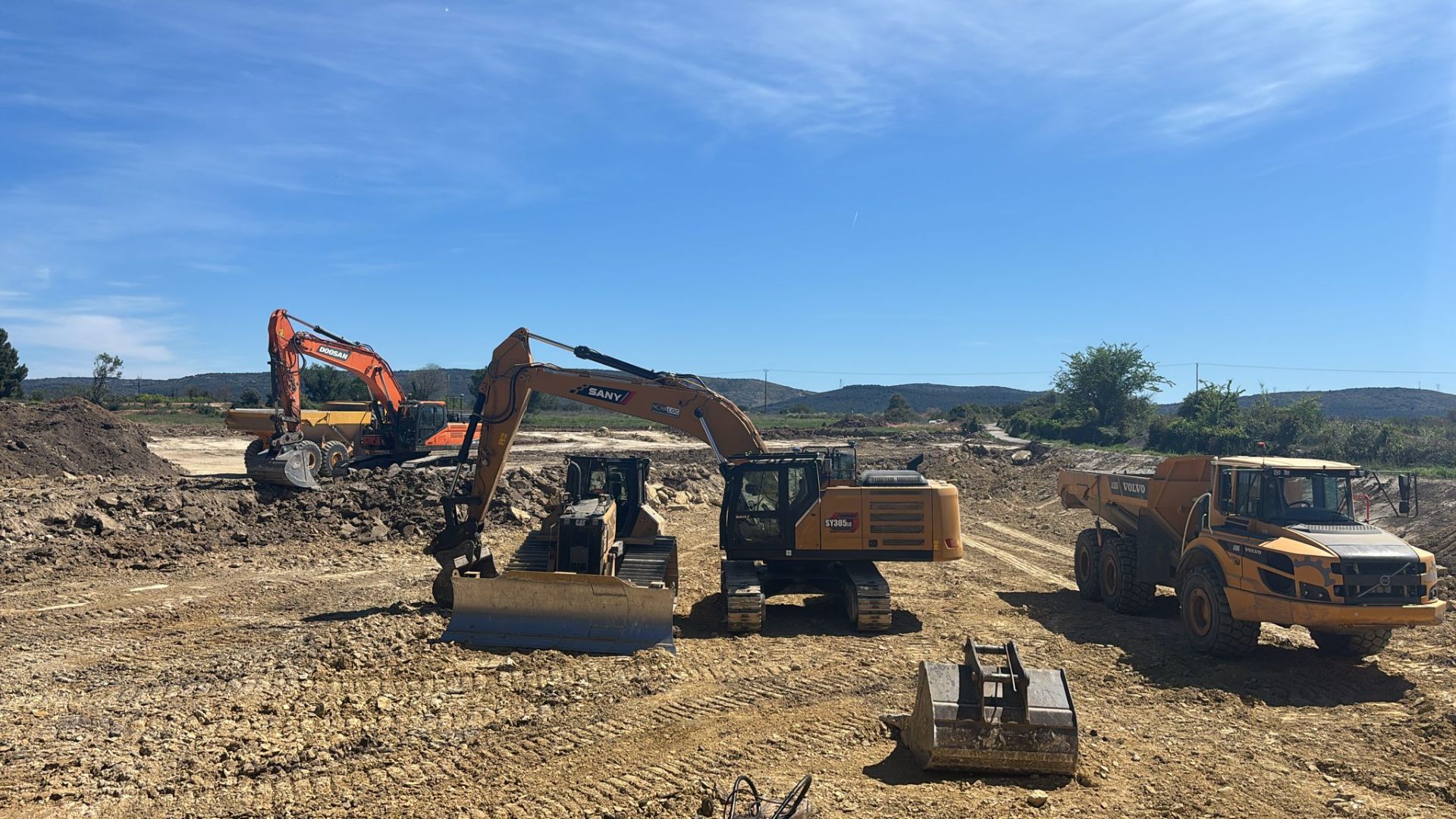 Chantier d'excavation en Occitanie — pelles mécaniques et tombereau évacuant des terres
